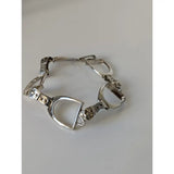 Silver steed stirrups bracelet with polished silver horsebit links and intricate equestrian design details