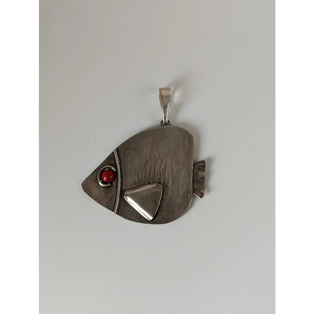 Silver steed angel fish silver pendant featuring a silver fish shape with a red gemstone eye and textured body