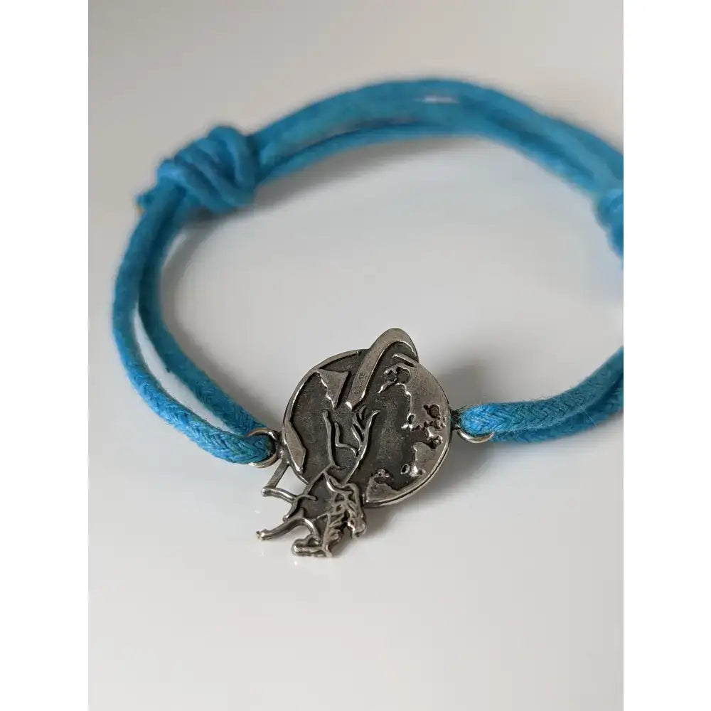 Silver steed world bracelet with a silver globe and astronaut charm on vibrant blue braided cord equestrian style