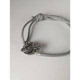 Silver steed world bracelet with silver charm of a horse rider around the globe on a braided gray cord equestrian style