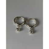 A pair of silver steed ball hoop earrings featuring sleek silver-toned huggie hoops with small spherical charms