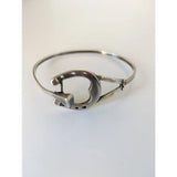 Silver steed big horseshoe bangle in sterling silver with a polished finish and small decorative holes along the curve