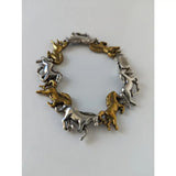 A silver steed galloping horses bracelet with alternating silver and brass horse charms in a dynamic design