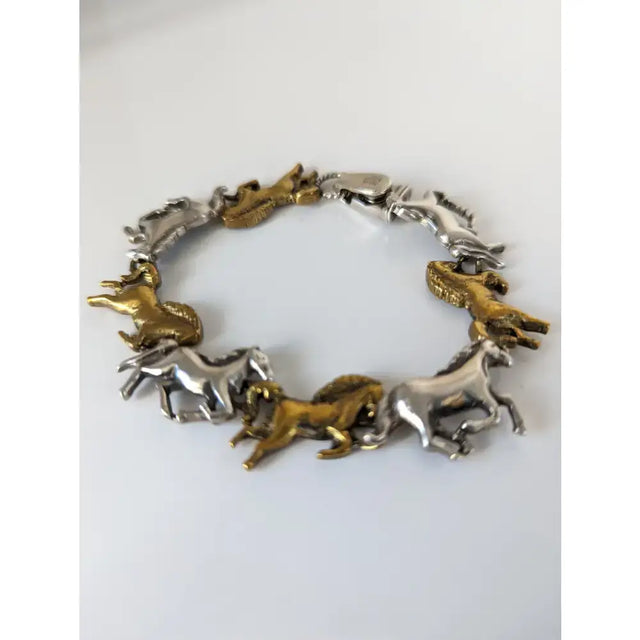 Silver steed silver and brass galloping horses bracelet with two-tone metallic horse figures in a running pose