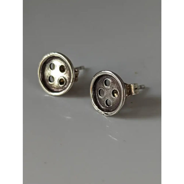 Silver steed button stud earrings in silver with a textured metallic finish and four-hole design stud earrings