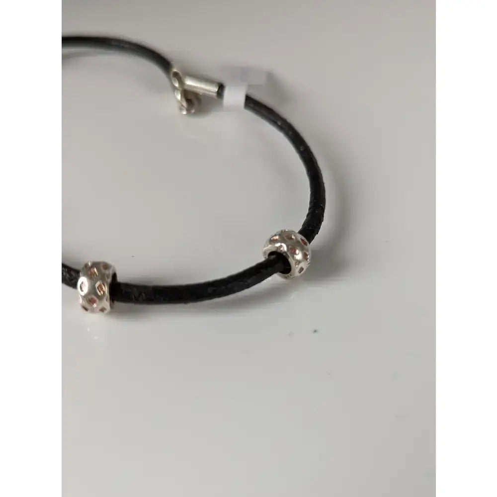 Black leather cord bracelet with silver steed silver charms textured bead charms and matching clasp on 26cm leather cord