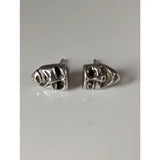 Silver steed comedy tragedy masks stud earrings featuring silver skull-shaped studs with intricate engraved details