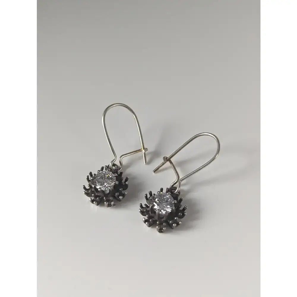 Silver steed crystal sunflower dropped earrings with handmade silver blackened petals and a clear central gemstone