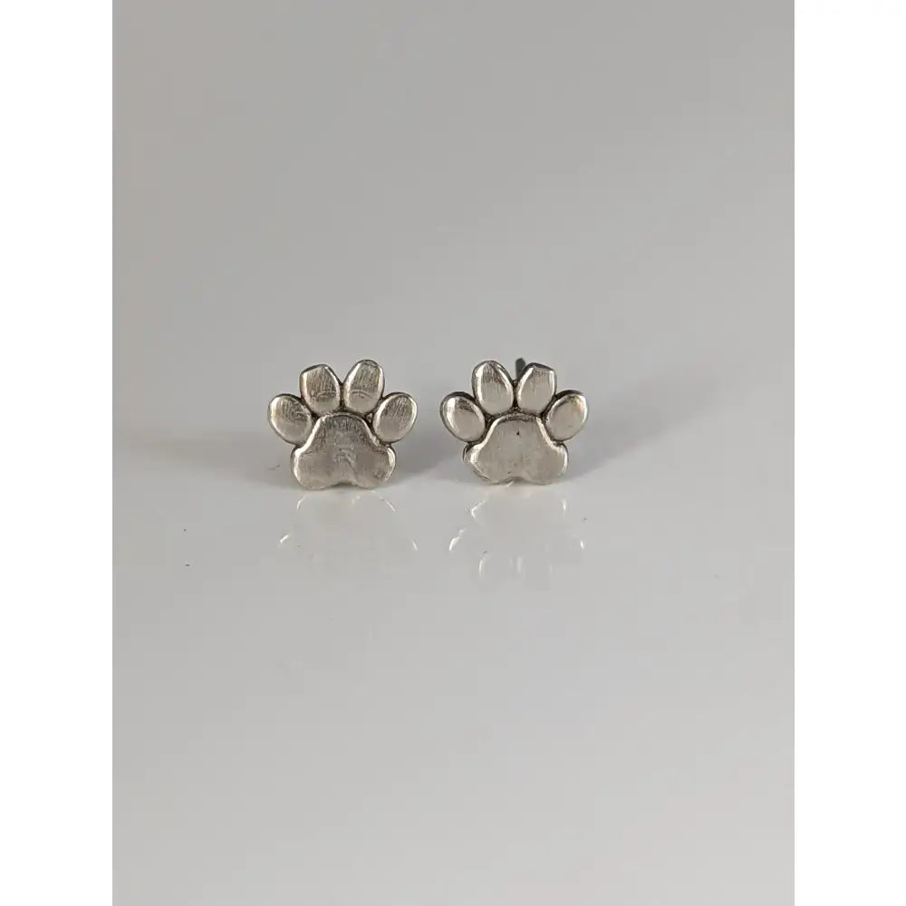 Silver steed sterling silver stud earrings featuring polished silver dog paws with a shiny metallic finish