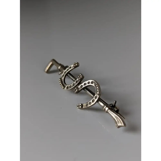 Silver steed double shoe silver brooch is a silver-colored metal stock tie pin shaped like three horseshoes with dotted detailing