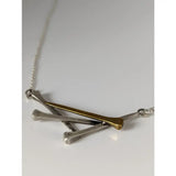 Silver steed elegant hoof nails necklace with a delicate silver chain and a pendant of one gold and two silver golf tees crossed