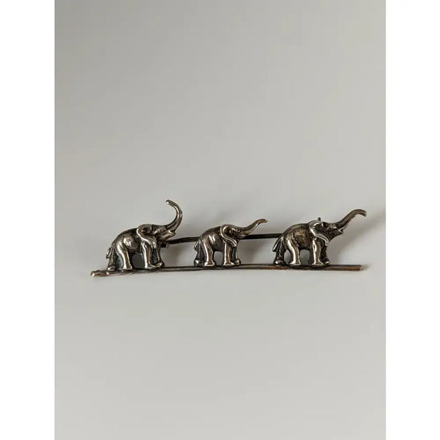 Silver steed elephants silver brooch with three detailed elephants raised trunks textured bodies in a line