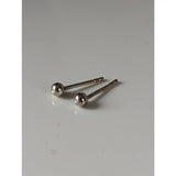 A pair of silver steed ball stud earrings featuring extra small polished silver balls with a unique shape and slender posts