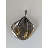Silver steed extravagant silver pendant with leaf shaped textured surface and two gold toned stems accents