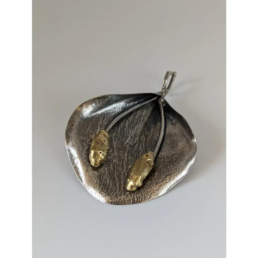 Silver steed extravagant silver pendant with textured leaf design and two gold-colored beetle charms on thin wires