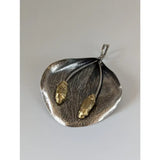 Silver steed extravagant silver pendant with textured leaf design and two gold-colored beetle charms on thin wires
