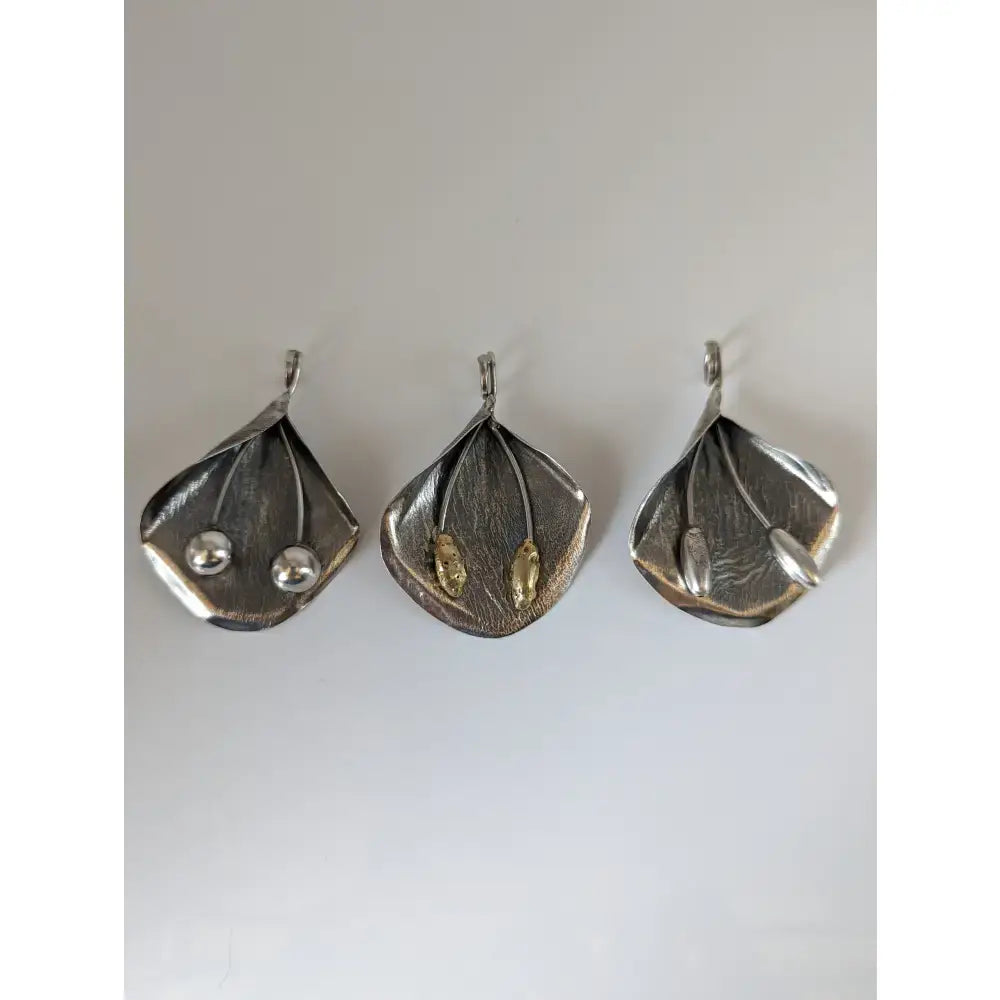 Three silver steed extravagant leaf pendants with unique inlaid details and gold accents stems silver pendant
