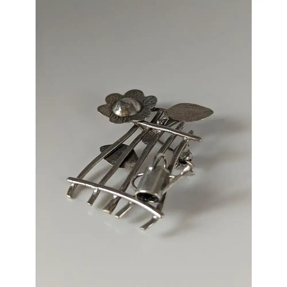 Silver steed garden silver brooch with flower, sphere, leaves, and watering can on arched metal frame for horse lovers