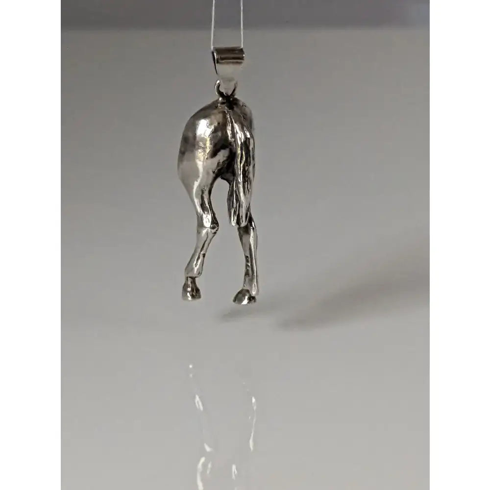 Silver steed hindquarters sterling silver pendant with detailed sculpted legs and tail hanging from simple metal bail