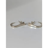Silver steed hoofnail stud earrings feature silver nail-shaped hoops with hammered texture and subtle engraved details