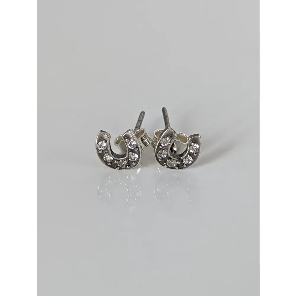 Silver steed horse shoe zirconia stud earrings featuring silver horseshoe shape with clear crystals