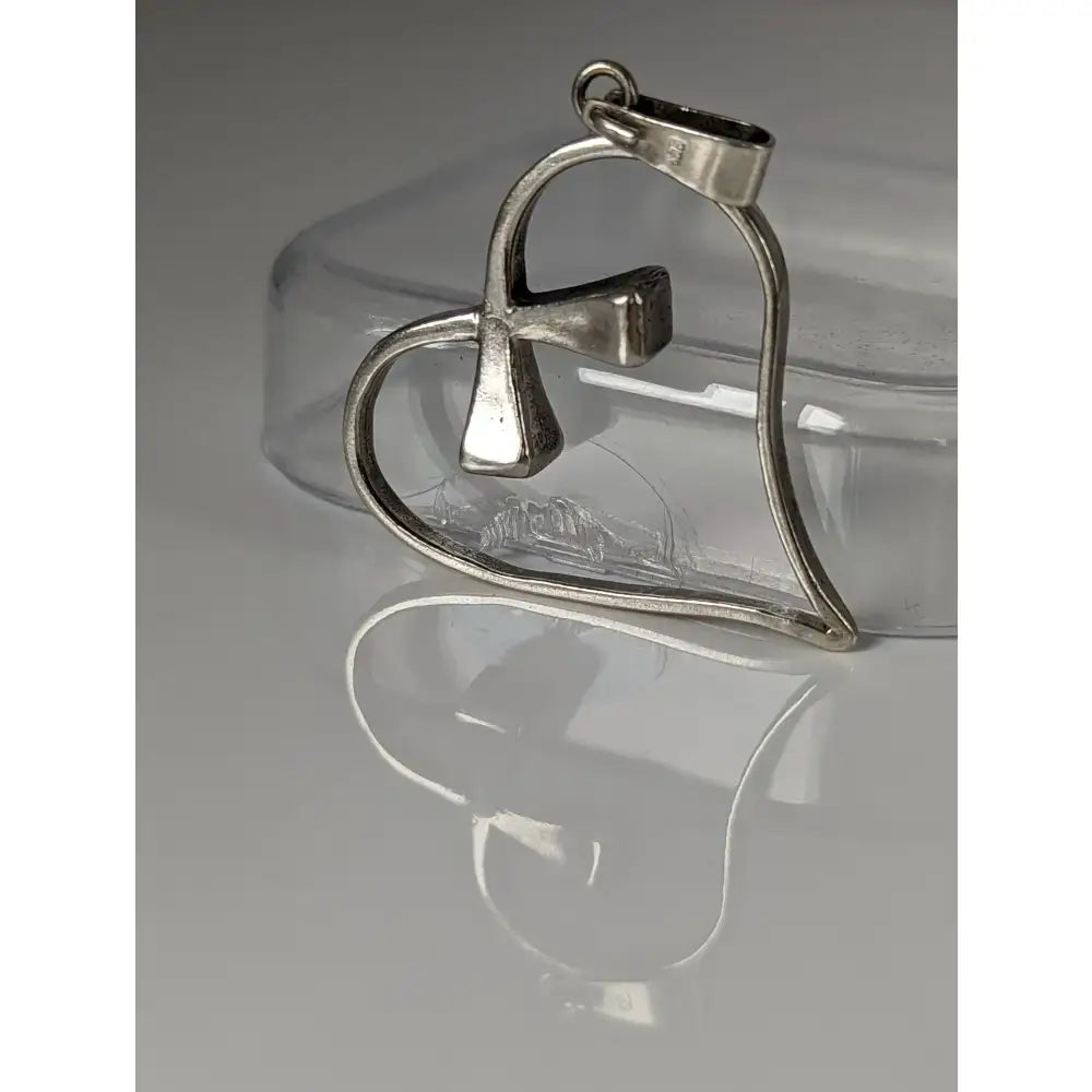 Silver pendant shaped like a heart with a cross design crafted from metal in the silver steed horseshoe collection