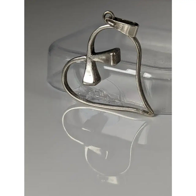 Silver pendant shaped like a heart with a cross design crafted from metal in the silver steed horseshoe collection