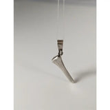 Silver steed silver pendant shaped like a horseshoe nail with polished metal finish on a clear cord