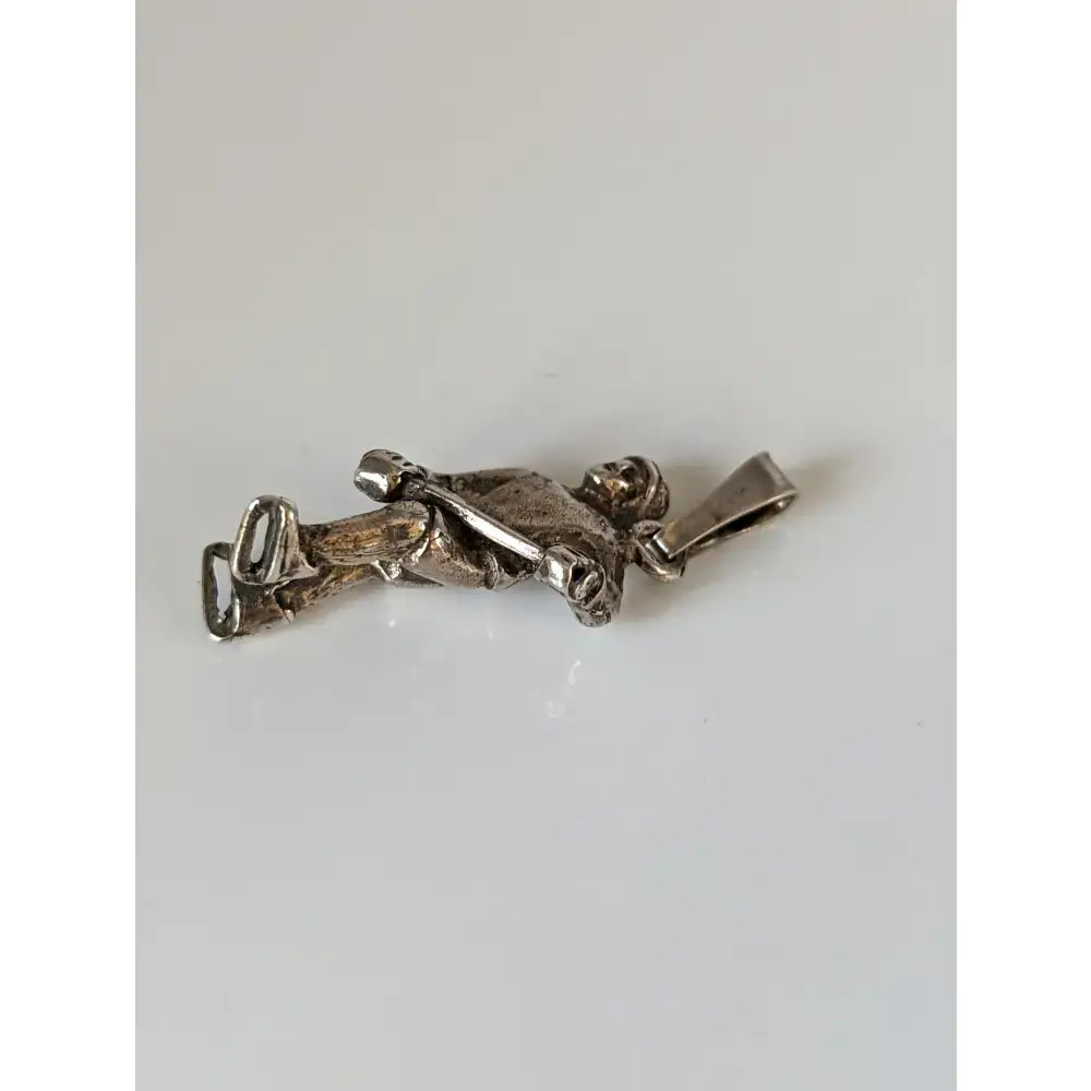 Silver steed ice hockey silver pendant showing a silver metal reclining figure holding an instrument for sports fans