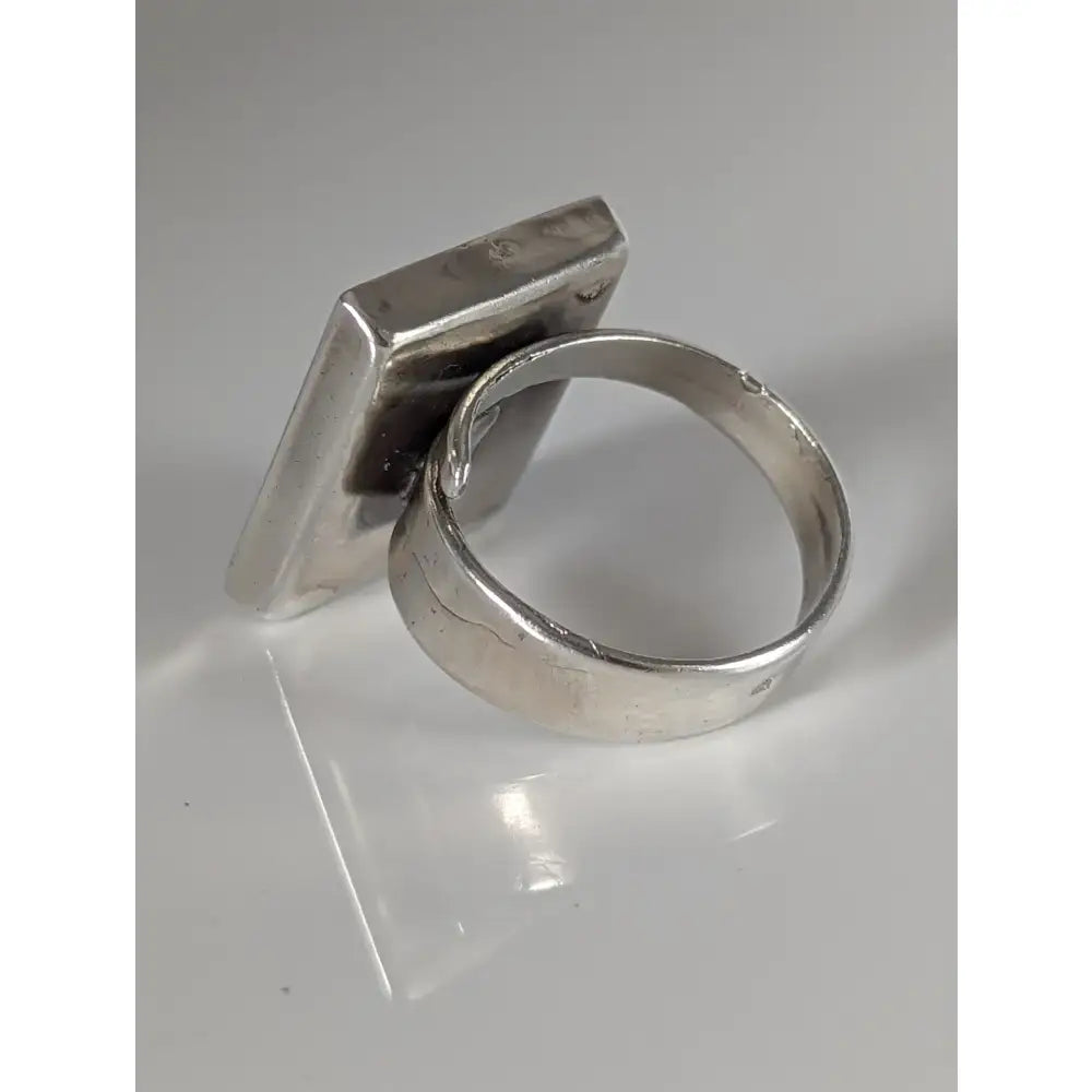 Silver steed large frame silver ring with a silver-toned rectangular textured face and smooth band featuring large unique rose details