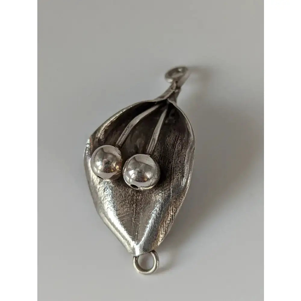 Silver steed leaf silver pendant with two polished sterling silver beads nestled in textured leaf design