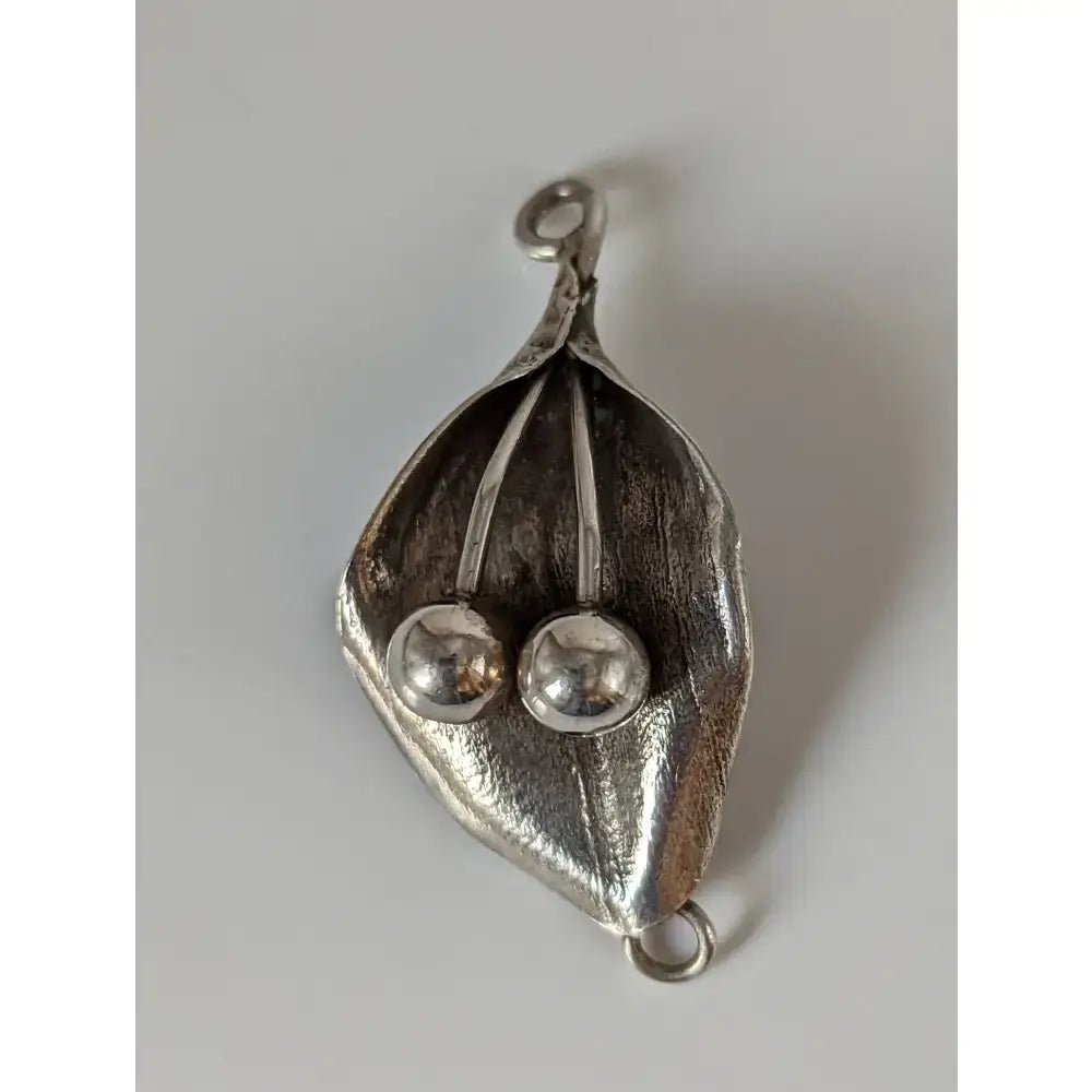 Silver steed leaf sterling silver pendant with textured silver leaf shape and two polished spherical beads nestled inside