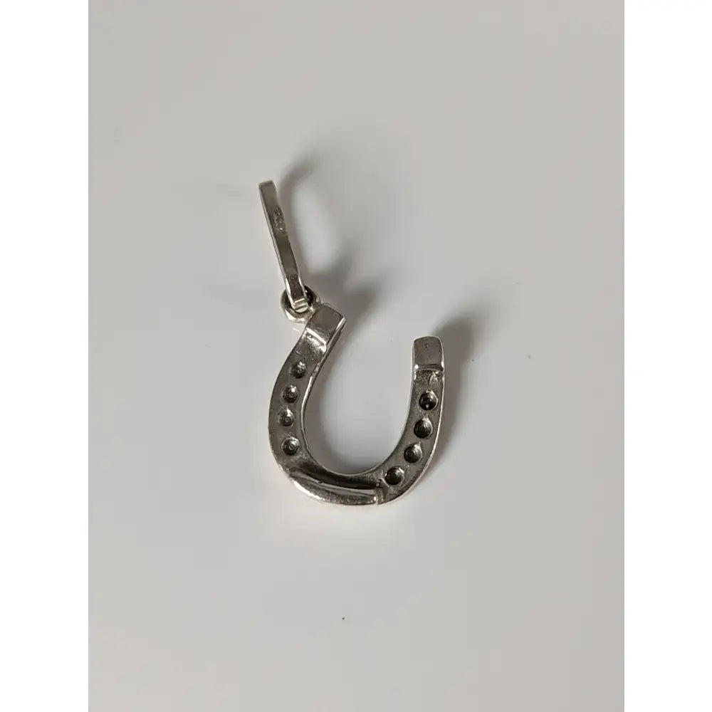Silver steed lucky horseshoe silver pendant in sterling silver with small black dots along its curve