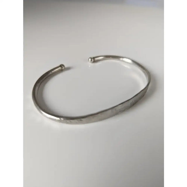 Silver steed magnetic solid silver bracelet featuring a sleek hammered cuff with rounded ends and minimalist design