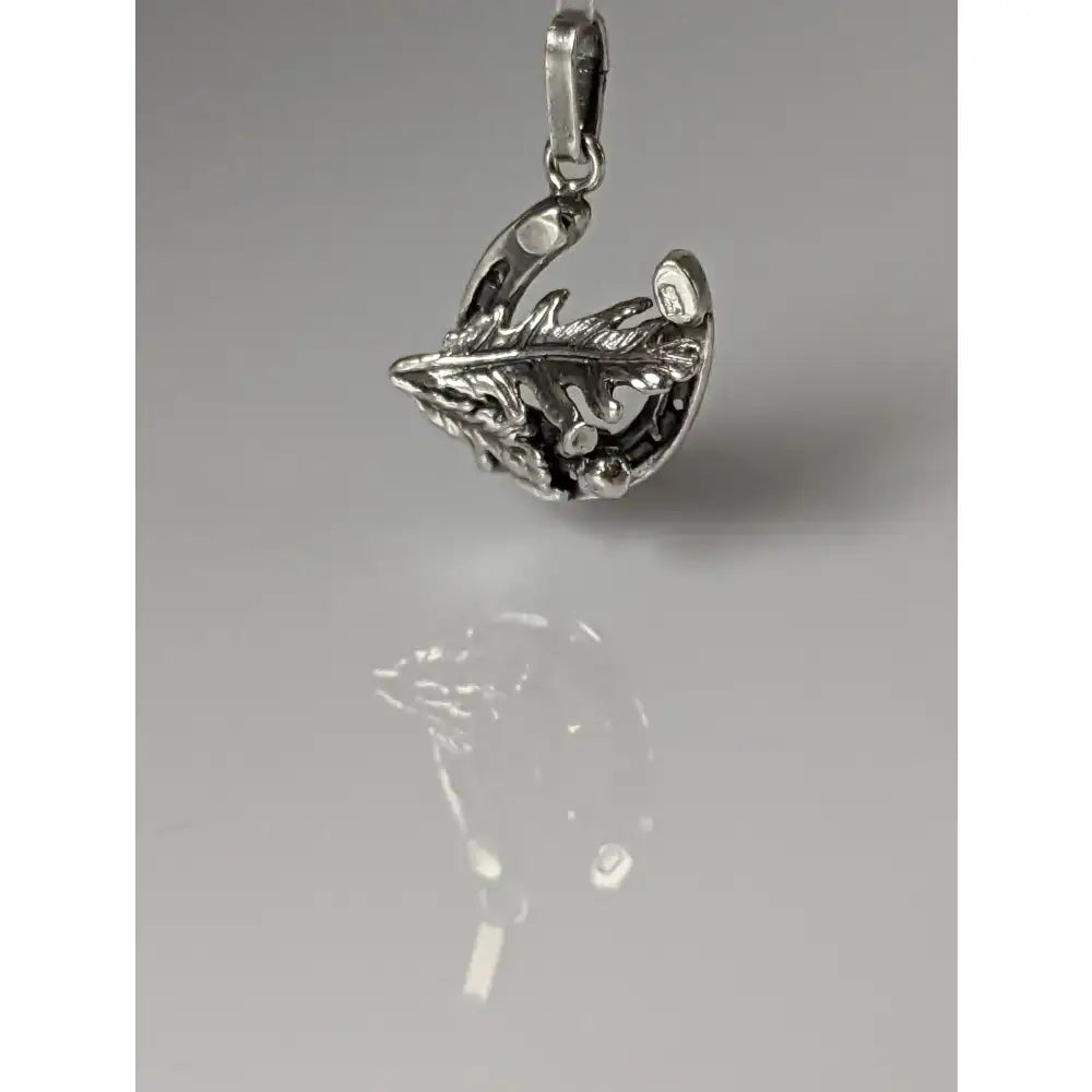Silver steed oak horseshoe silver pendant featuring a detailed silver feather design with a small embedded gemstone