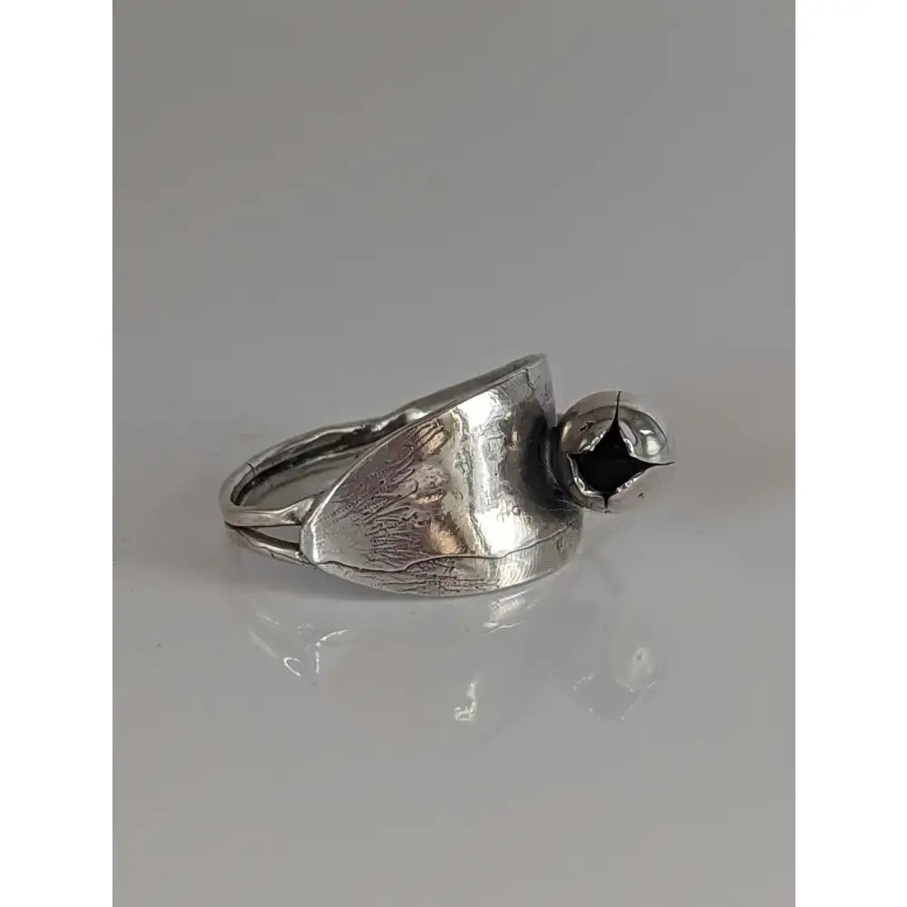 Silver steed round bud ring with silver leaf-textured band and small black stone accent in a round bud design