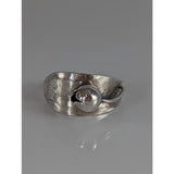 Silver steed round bud ring with a silver-toned hammered band and embossed leaf centerpiece