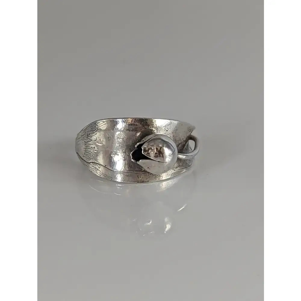 Silver steed round bud ring with silver-toned hammered band and embossed leaf design