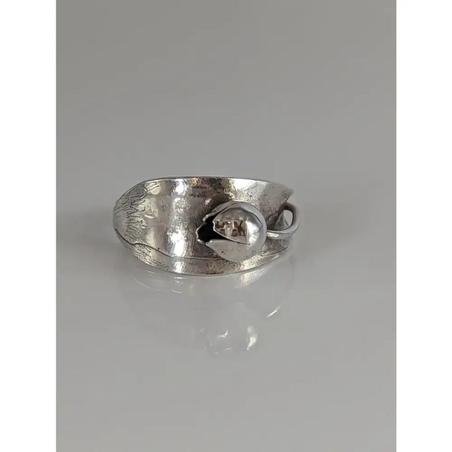 Silver steed round bud ring with silver-toned hammered band and embossed leaf design