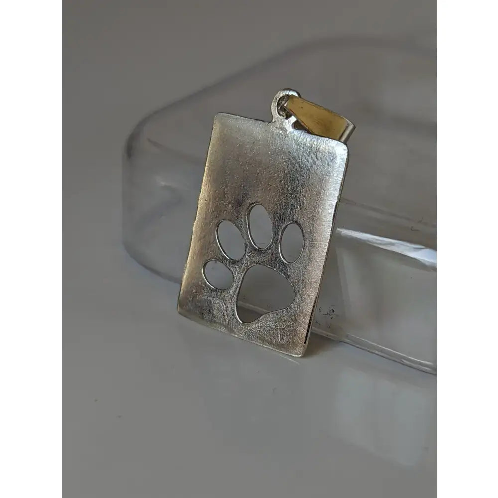 Silver steed paw silver pendant with a silver rectangular paw print tag and gold-toned bail for everyday wear