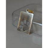 Silver steed paw silver pendant with a silver rectangular paw print tag and gold-toned bail for everyday wear
