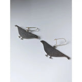 Silver steed pigeon dropped earrings featuring silver pigeon shapes with detailed engraved feathers and small black eyes