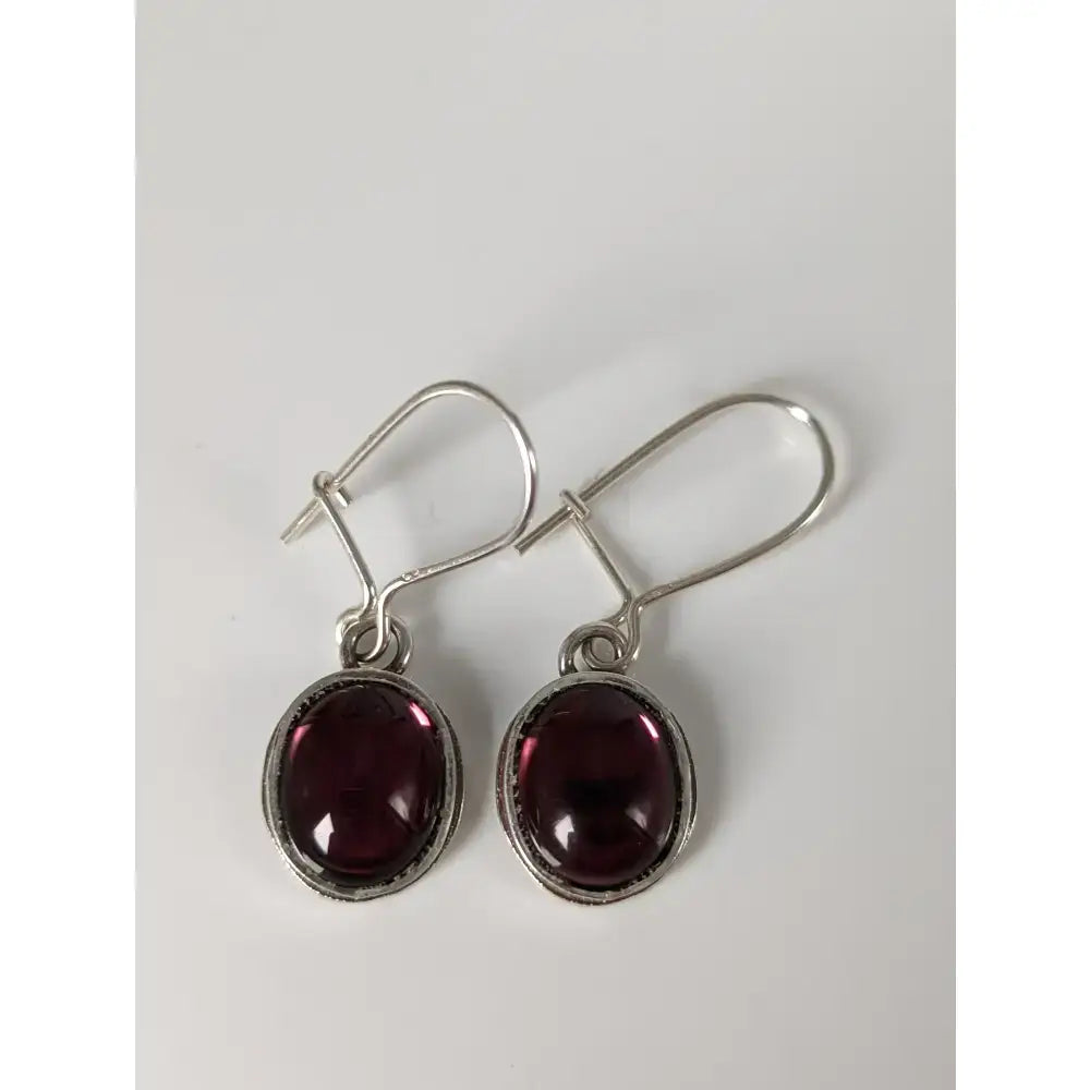 Silver steed purple crystal dropped earrings with oval deep red garnet stones in textured silver bezel
