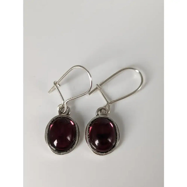 Silver steed purple crystal dropped earrings with oval deep red garnet stones in textured silver bezel