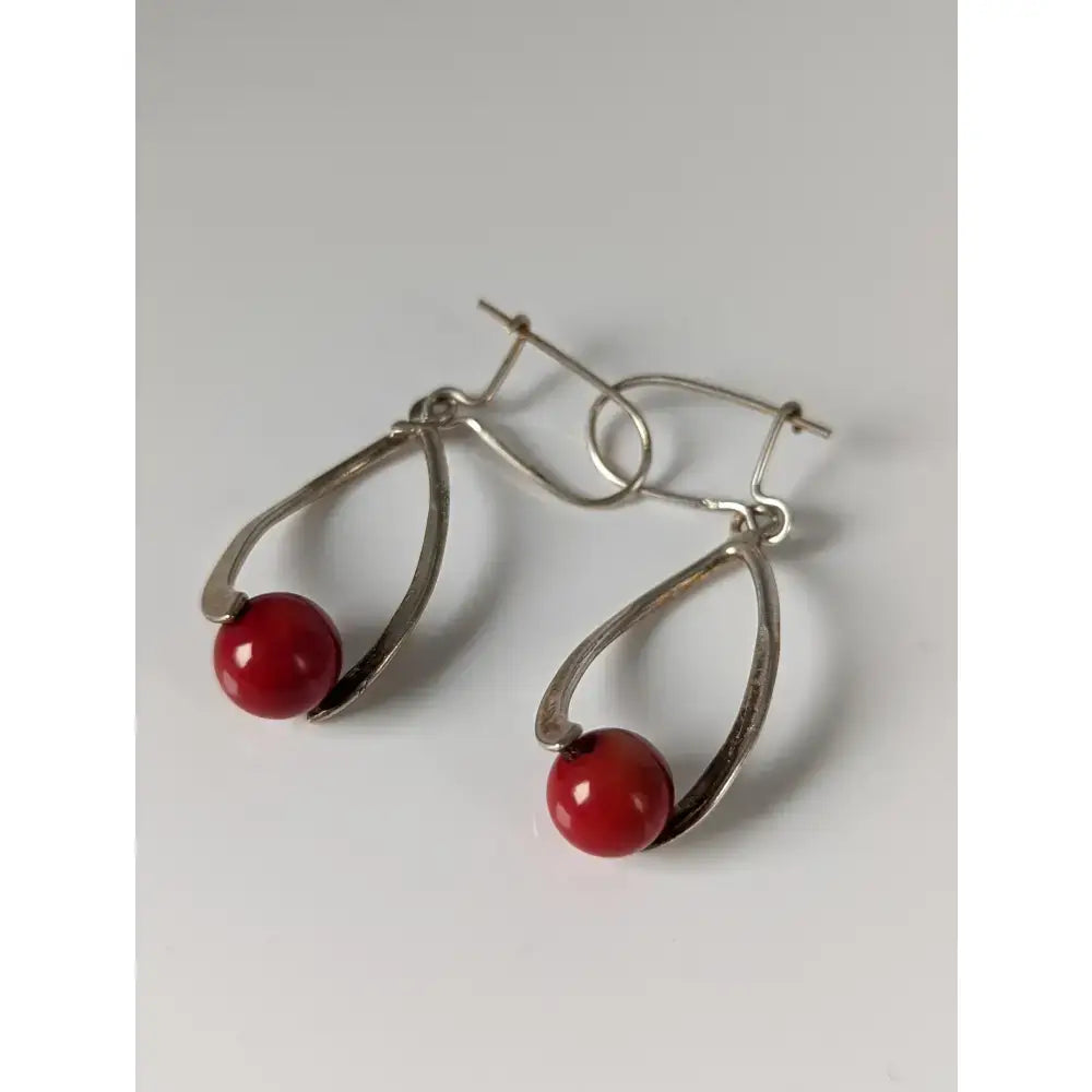 Silver steed red bead dropped earrings with silver teardrop shape and polished red spherical bead at the bottom