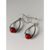Silver steed red bead dropped earrings with silver teardrop shape and polished red spherical bead at the bottom