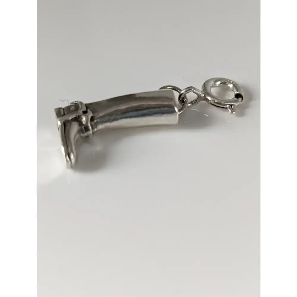 Silver charm shaped like a miniature nail clipper with polished finish and attached to a small chain for riding boot silver collection