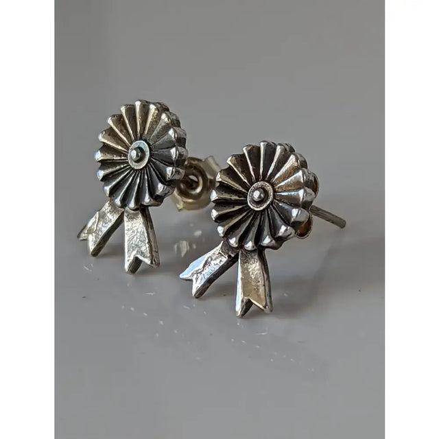 Silver steed rosette stud earrings with silver ribbon-themed sunburst design and textured metallic finish
