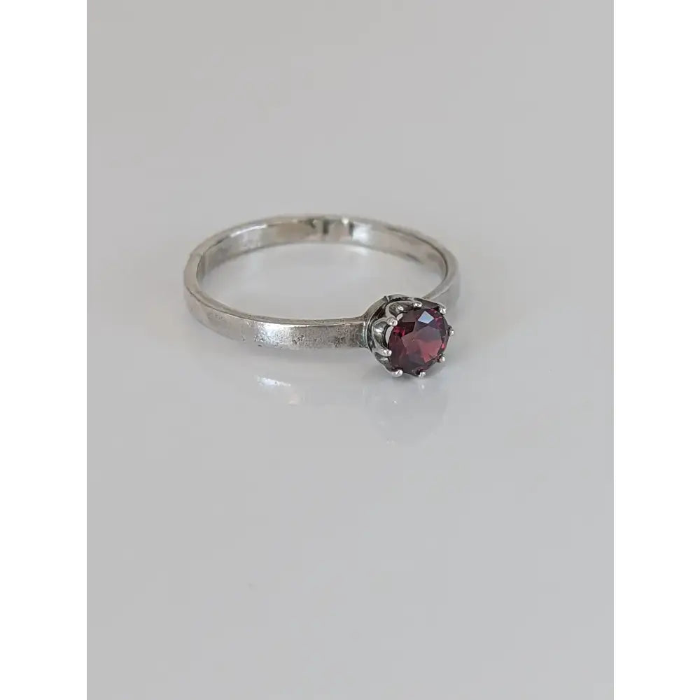 Silver steed silver ruby zirconia ring with a textured band and a round deep red gemstone in a six-prong setting
