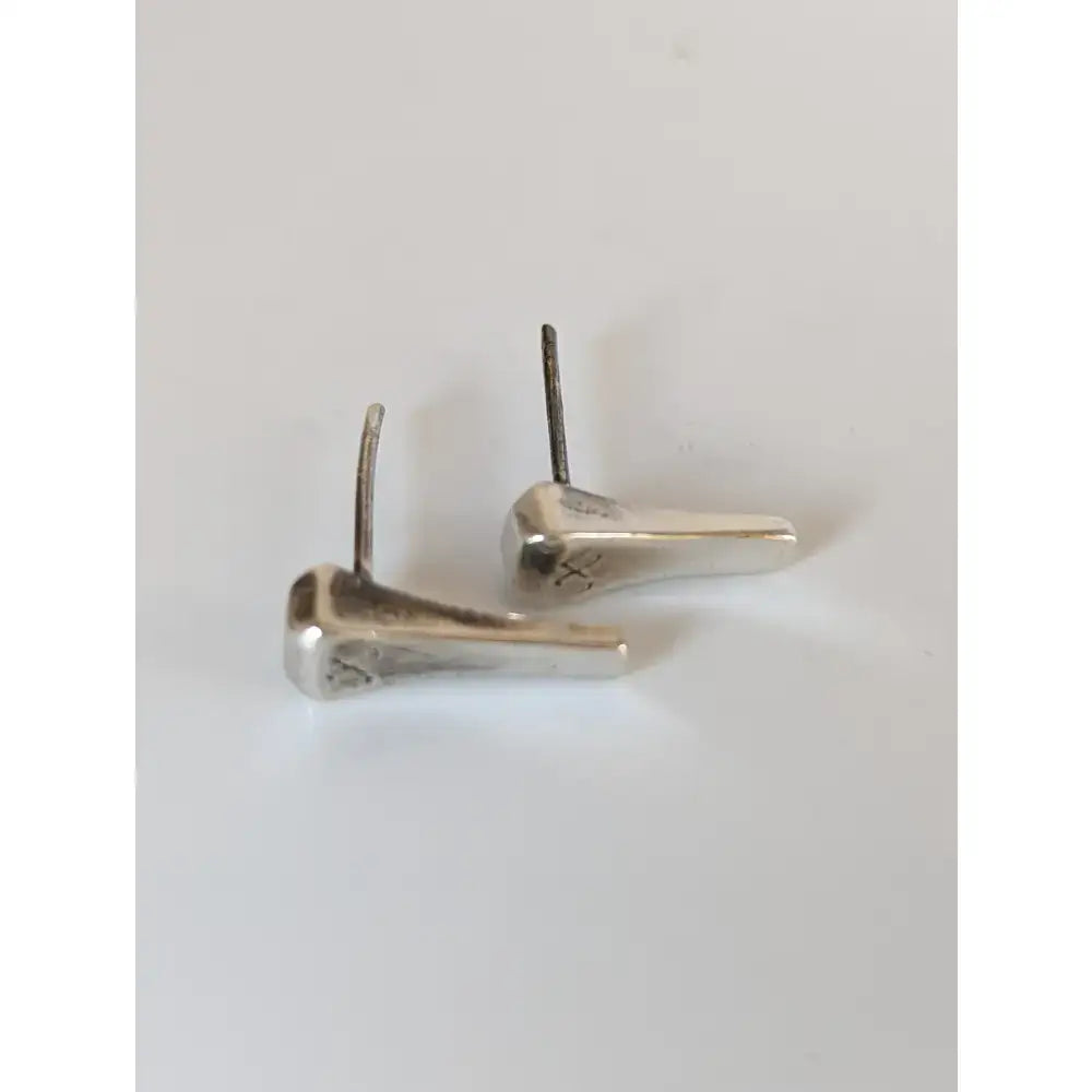 Silver steed silver-toned stud earrings shaped like short hoof nail horseshoes with a polished metallic finish